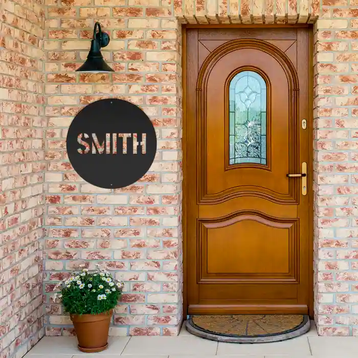 Smith Family Name Sign in black, hung beside a brick entrance